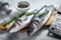 Raw seabass fish on a cutting board with spices, herbs. White background. Top view Royalty Free Stock Photo