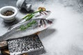 Raw seabass fish on a cutting board with spices, herbs. White background. Top view. Copy space Royalty Free Stock Photo