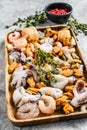 Raw seafood mix in a wooden bowl. Gray background. Top view