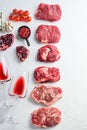 Raw set of alternative beef cuts Chuck eye roll, top blade, rump steak with red wine in glass and bottle, herbs and pomegranate. Royalty Free Stock Photo