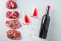 Raw set of alternative beef cuts Chuck eye roll, top blade, rump steak with red wine in glass and bottle. Organic meat. White