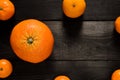 Raw several mandarins and orange isolated on black wooden background