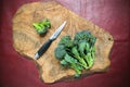 Raw sicilian broccoli and knife on wooden cutting board