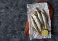 Raw Sillago fish on baking paper with lime and rosemary Royalty Free Stock Photo