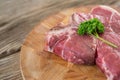 Raw Sirloin chop and corainder leaves on wooden tray against wooden background