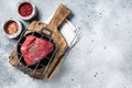 Raw sirloin or rump steak on a grill ready for cooking. Gray background. Top view. Copy space Royalty Free Stock Photo