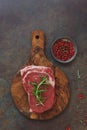 Raw sirloin steak with rosemary on cutting board Royalty Free Stock Photo