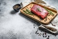 Raw Sirloin steak on a wooden tray. Beef meat. Gray background. Top view. Space for text Royalty Free Stock Photo