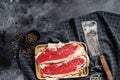 Raw sirloin steak on a wooden tray with a meat cleaver. Marble beef. Black background. Top view. Copy space Royalty Free Stock Photo