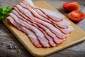 Raw sliced bacon on wooden board Royalty Free Stock Photo