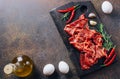 Raw sliced beef bacon ready for cooking on dark black concrete background Royalty Free Stock Photo