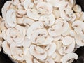 Raw sliced button mushrooms on old frying pan, top view Royalty Free Stock Photo