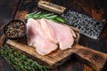 Raw sliced cut chicken breast fillet cutlets on a wooden cutting board with cleaver. Dark wooden background. Top view Royalty Free Stock Photo