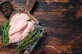 Raw sliced cut chicken breast fillet cutlets on a wooden cutting board with cleaver. Dark wooden background. Top view Royalty Free Stock Photo