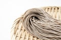 Raw soba noodles in a bamboo colander placed against a white background Royalty Free Stock Photo