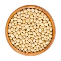 Raw soybeans, whole and dried soy or also soya beans, in a wooden bowl