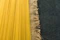 Raw long spaghetti on a black background. Yellow Italian pasta. Raw spaghetti bolognese. Copy space.