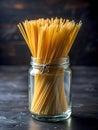Raw spaghetti in a clear glass jar on a black dining table Royalty Free Stock Photo