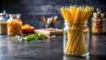 Raw spaghetti in a clear glass jar on a black dining table Royalty Free Stock Photo