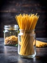 Raw spaghetti in a clear glass jar on a black dining table Royalty Free Stock Photo