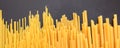 Raw spaghetti and macaroni pasta on black background, banner Royalty Free Stock Photo