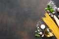 Raw spaghetti with parmesan cheese, olive oil, basil and garlic on a concrete background. Ingredients for cooking pasta with pesto Royalty Free Stock Photo