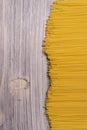 raw spaghetti pasta scattered on wooden table, close-up view from above Royalty Free Stock Photo