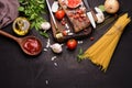 Raw Spaghetti Pasta with Seasoning With tomato sauce and basil garlic onions spaghetti tomatoes wooden spoon and fork placed on a Royalty Free Stock Photo