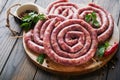 Raw spiral pork sausages. Fresh pork sausages tasty twisted spiral for bbq on white stand with spices and herbs for Octoberfest pa Royalty Free Stock Photo