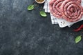 Raw spiral pork sausages. Fresh pork sausages tasty twisted spiral for bbq on white stand with spices and herbs for Octoberfest pa Royalty Free Stock Photo