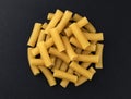 Raw spiral tortiglioni pasta isolated on black background, top view