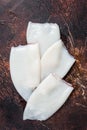 Raw Squid or Calamari tubes on a kitchen table. Dark background. Top view