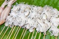 Raw squid and octopus skewers on banana leaf