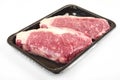 Raw steak in an airtight vacuum package on a white background.