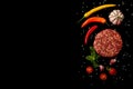 Raw steak cutlets from minced beef meat isolated on black background. Fresh vegetables, mint Royalty Free Stock Photo