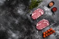 Raw steak of marbled beef in vacuum plastic pack, on black dark stone table background, top view flat lay, with copy space for Royalty Free Stock Photo