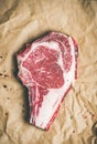 Raw steak rib-eye with seasoning on craft paper, copy space Royalty Free Stock Photo