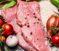 Raw steak turkey tomatoes garlic onion rice in a frying pan top view close up