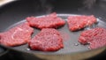 Raw Steaks Cooking on Nonstick Pan.