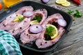 Raw steaks river fish on the grill pan on a wooden table.