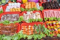 Raw steaks, sausages, meat, and vegetables on skewers in Vietnamese street market