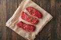 Raw steaks. Top blade steaks on wood burning board with spices, rosemary, vegetables and ingredients for cooking on old wooden bac
