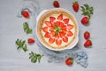 Raw strawberry cheesecake in a baking dish on the gray background decorated with many fresh strawberries, mint leaves Royalty Free Stock Photo