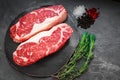 Raw striploin beef steak with rosemary, salt and pepper Royalty Free Stock Photo