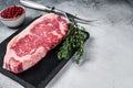 Raw striploin or new york strip steak on a marble board. White background. Top view. Copy space