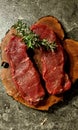 Raw Striploin Steaks on wooden board