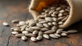 Raw sunflower seeds with gray stripes spilling from burlap sack on rustic surface Royalty Free Stock Photo