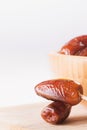 Raw sweet dry dates with in a terracotta bowl on a white background. Organic sweeties to healty eating. Ramadan kareem