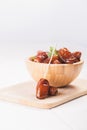 Raw sweet dry dates with in a terracotta bowl on a white background. Organic sweeties to healty eating. Ramadan kareem