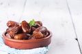 Raw sweet dry dates with in a terracotta bowl on a white background. Organic sweeties to healty eating. Ramadan kareem